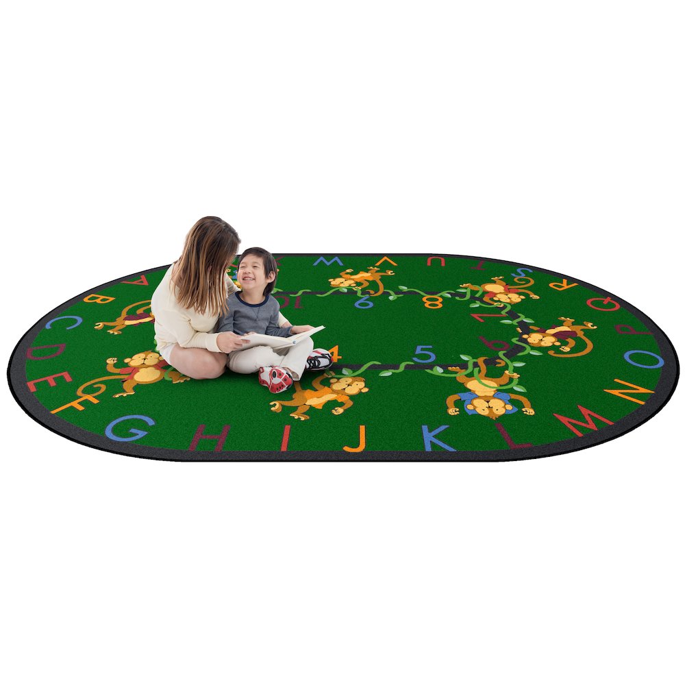 Kid Essentials Monkey Business 7'8" x 10'9" Oval Area Rug in Color Green. Picture 2