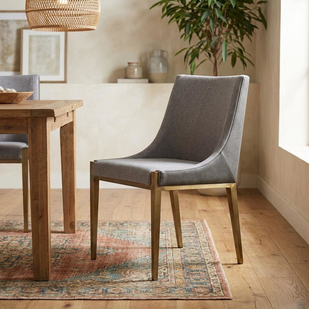 Modern grey and brass dining chair with padded seat and sleek design. Picture 2